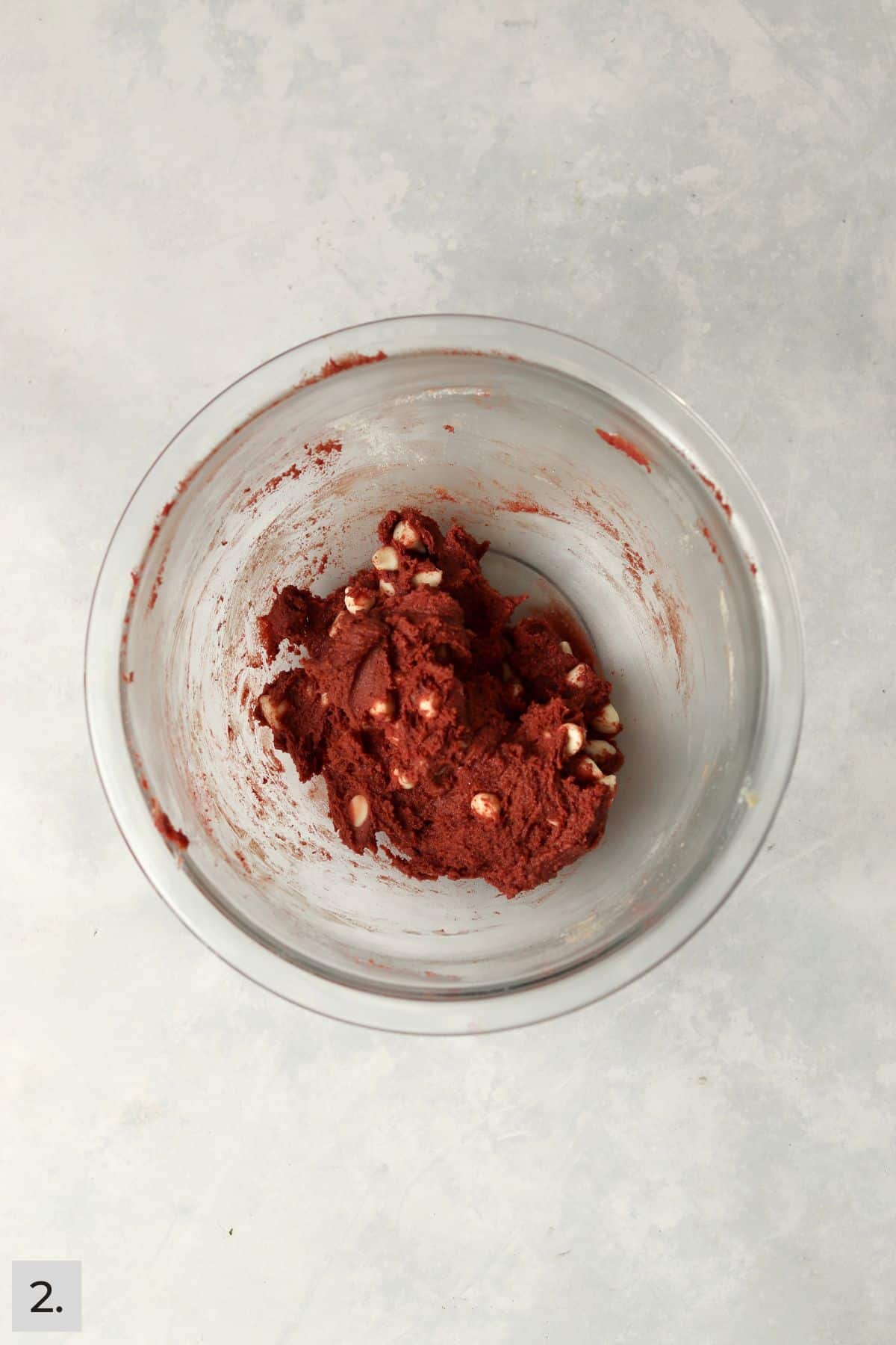 Small batch of red velvet cookie dough with white chocolate chips in a mixing bowl.