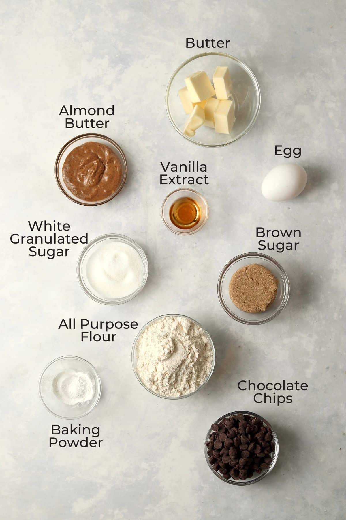 Ingredients for almond butter chocolate chip bars in glass prep bowls.