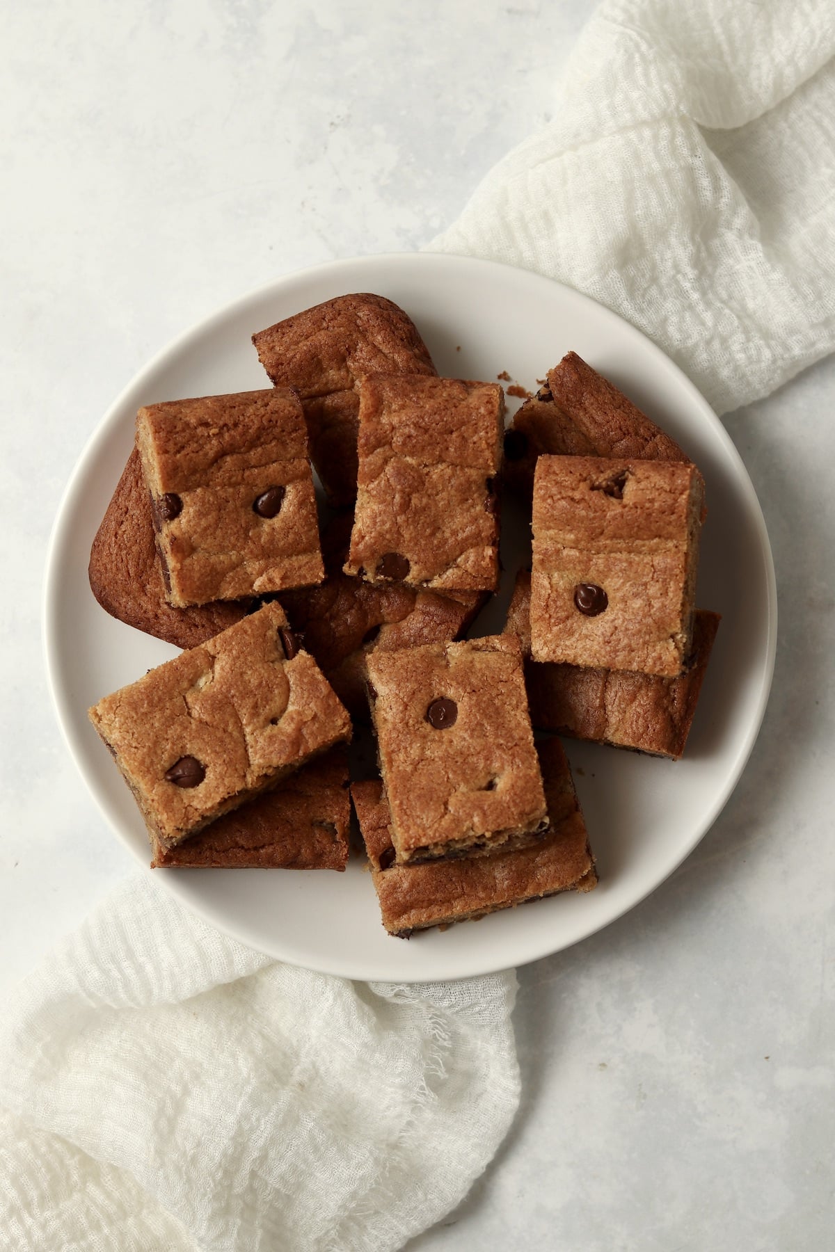 Plate of almond butter chocolate chip cookie bars cut into squares.