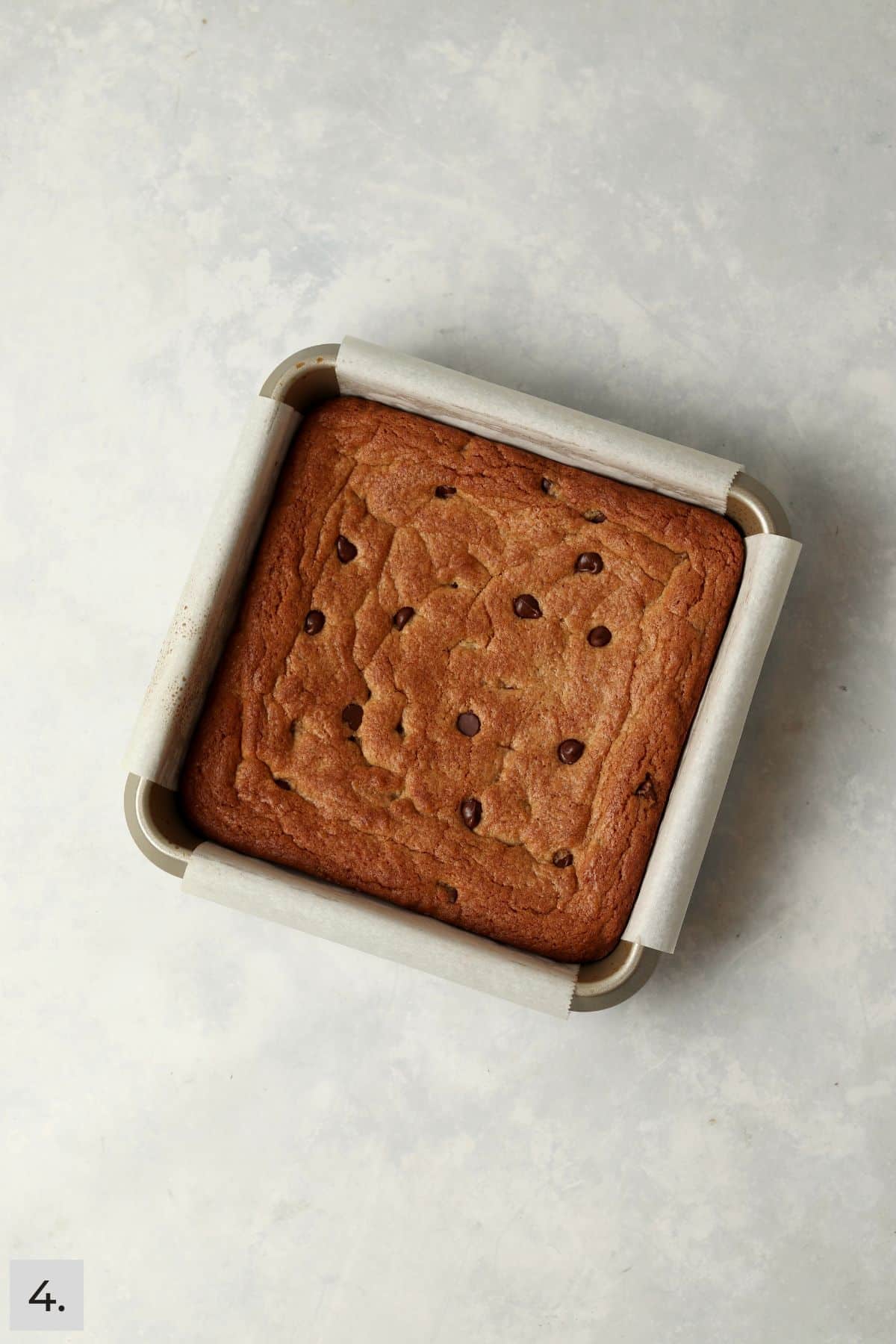 Baked almond butter chocolate chip bars in a square baking pan.