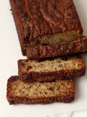 A loaf of moist banana bread made with oil cut into slices.