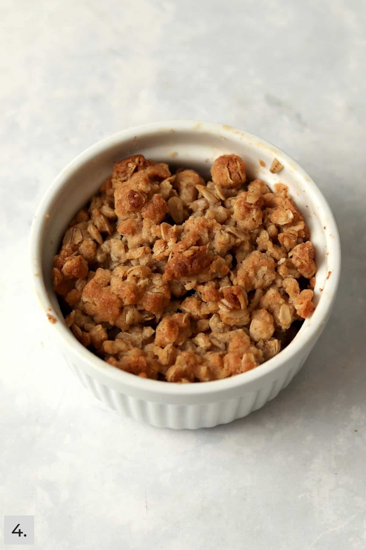 A baked single serve apple crisp in a ramekin.