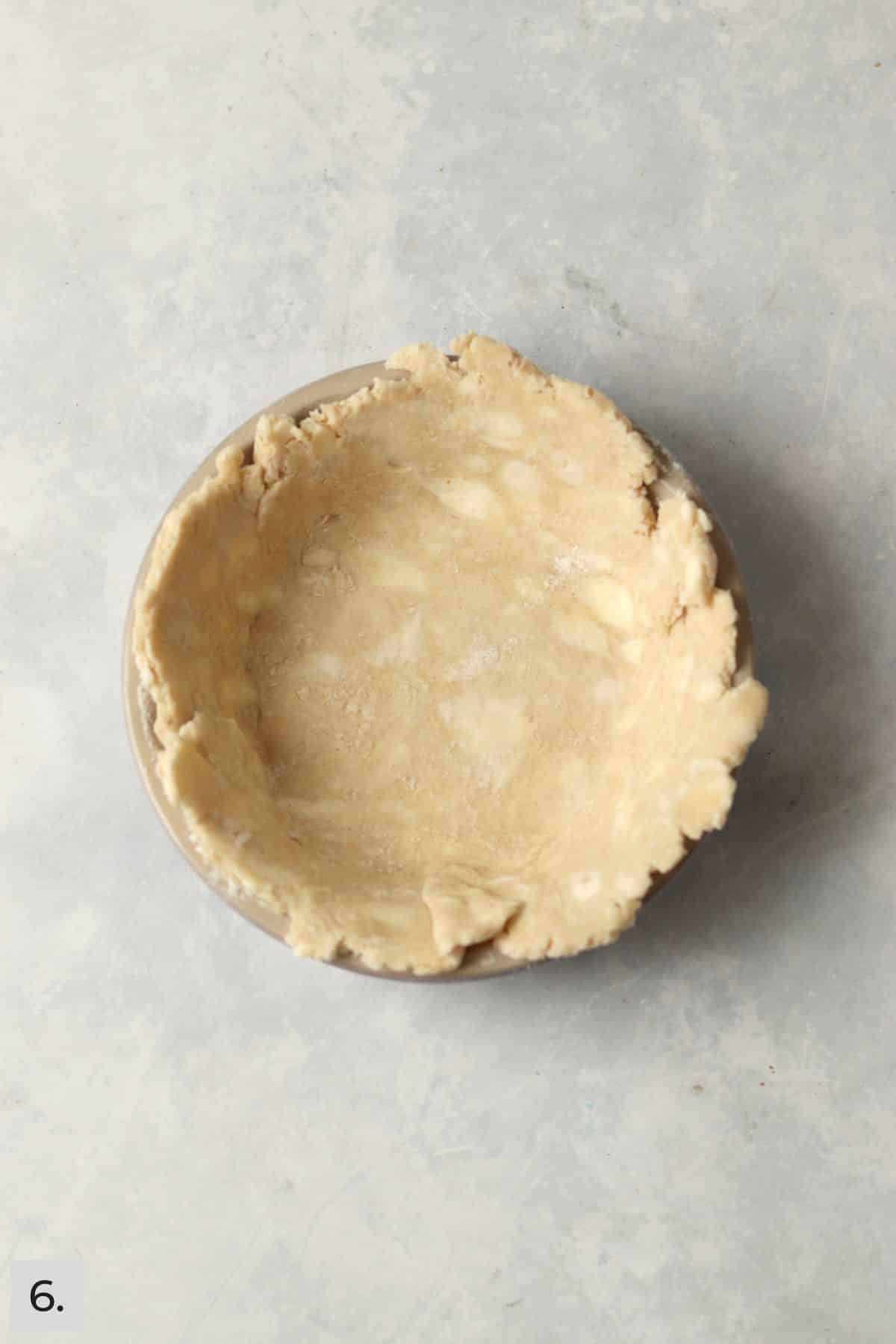 Unbaked butter pie crust in a 5 inch pie dish.