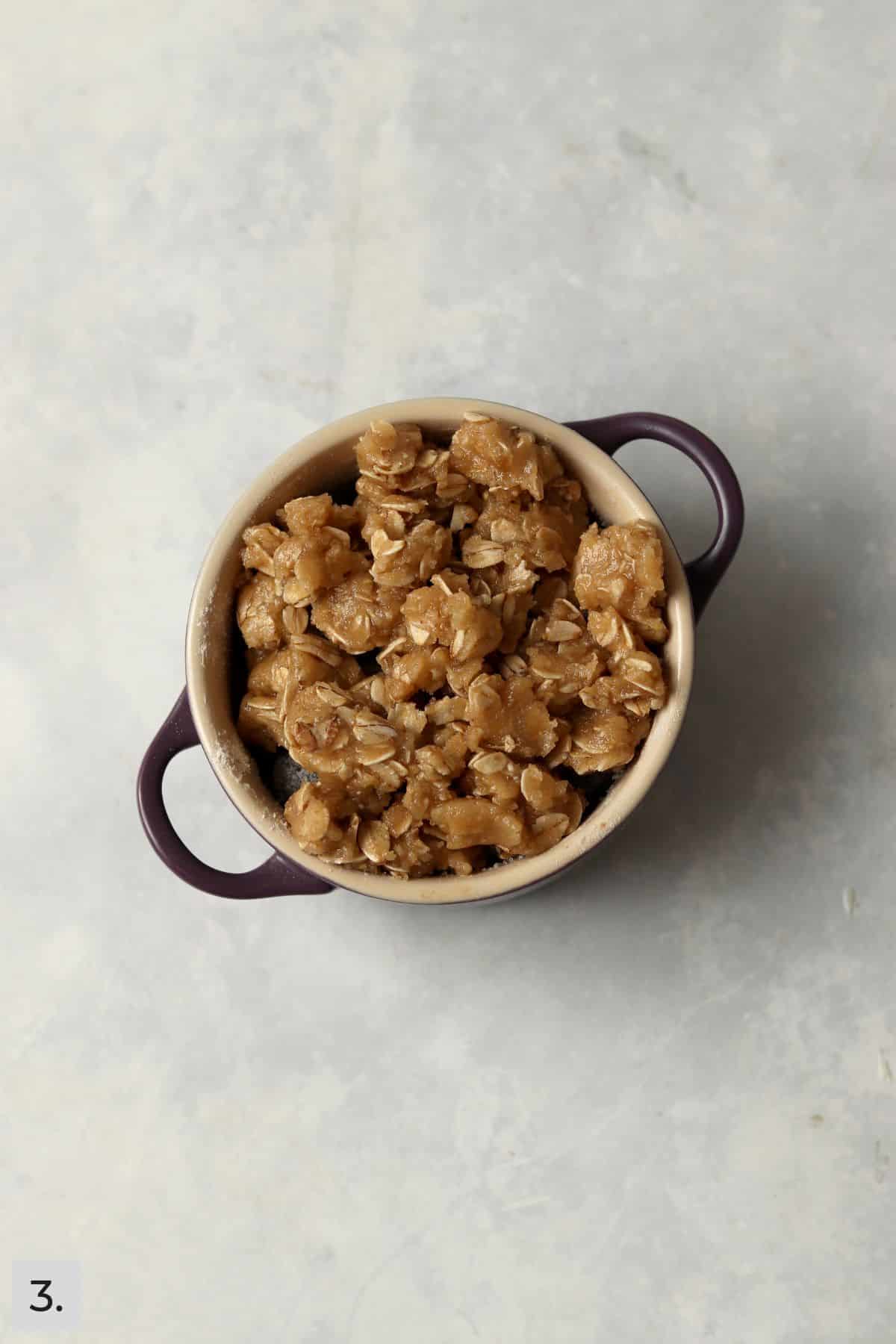 Unbaked single serve blueberry crisp in a ramekin.