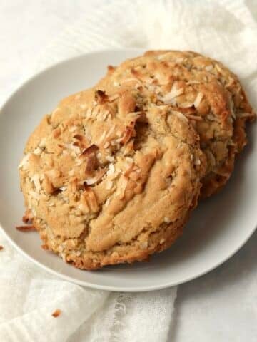 Single serve coconut cookie on a plate with shredded coconut.