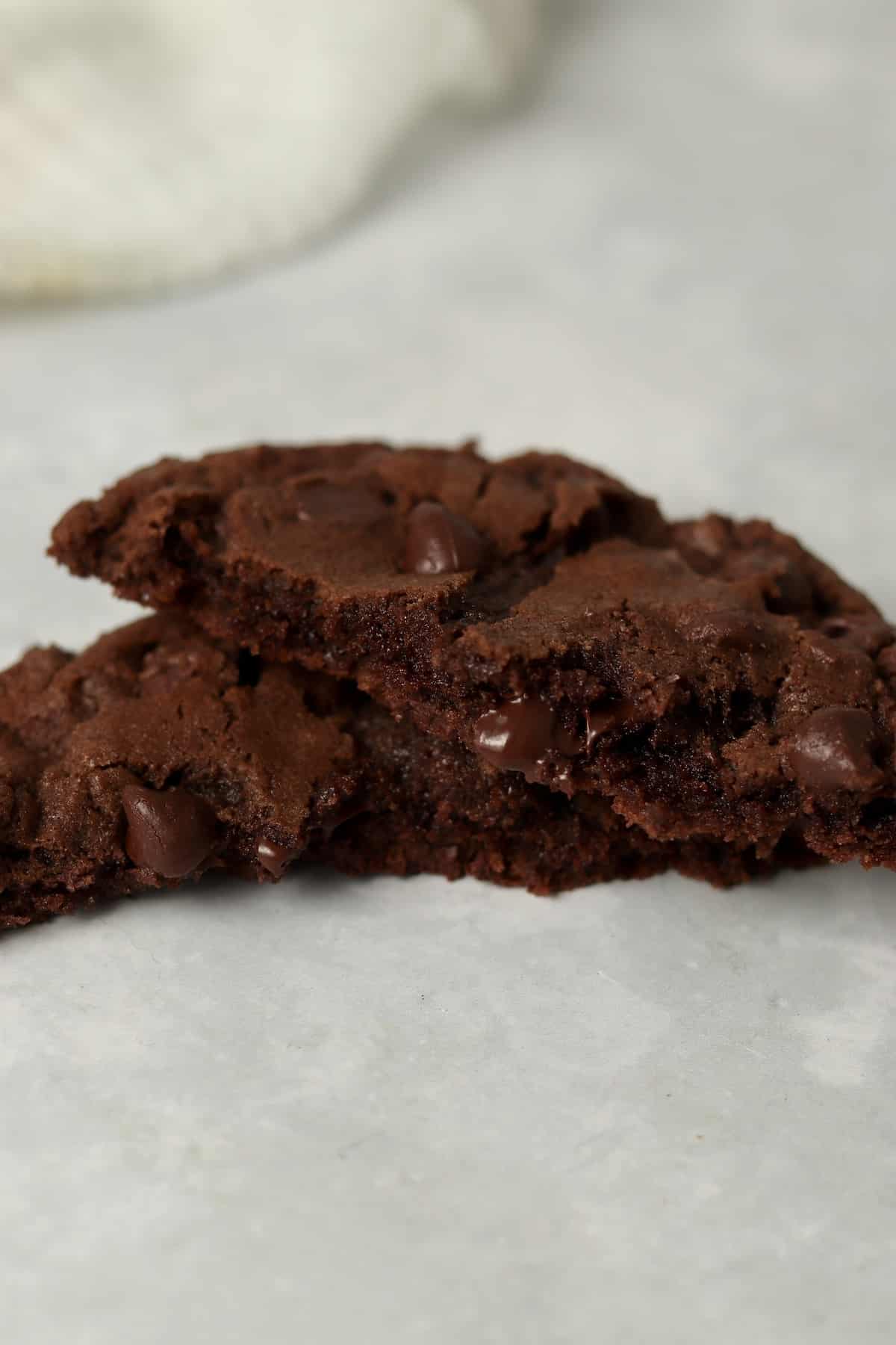 A double chocolate cookie broken in half to show gooey center.