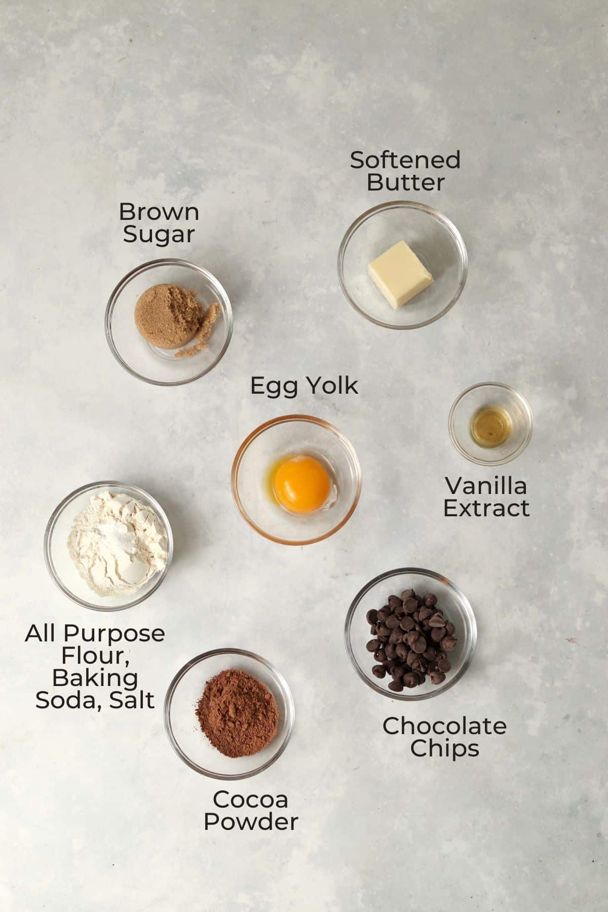Ingredients to make a small batch of double chocolate cookies in small glass prep bowls.
