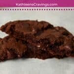 One double chocolate cookie broken in half to show gooey inside.