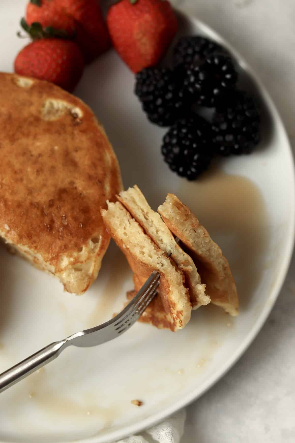 Fork with bite of pancakes to show fluffy texture.