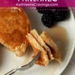 Fork holding a bite of fluffy pancakes.