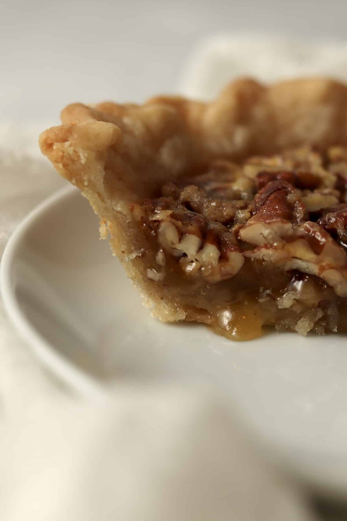 Piece of a single serve pecan pie on a plate to show filling.