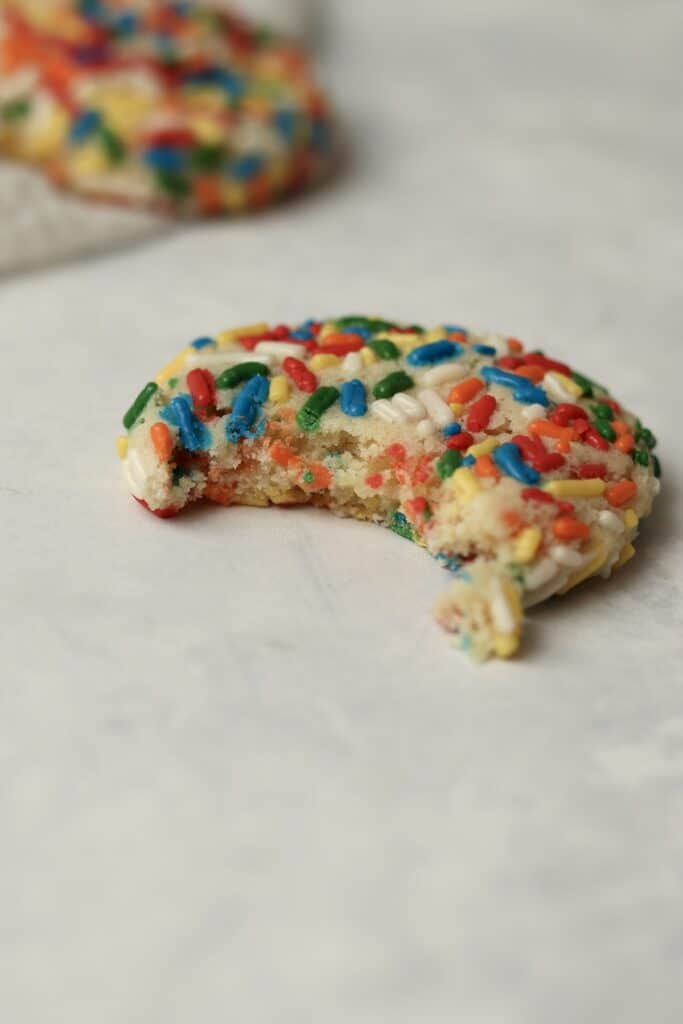 Sprinkle sugar cookie with bite taken out of it.
