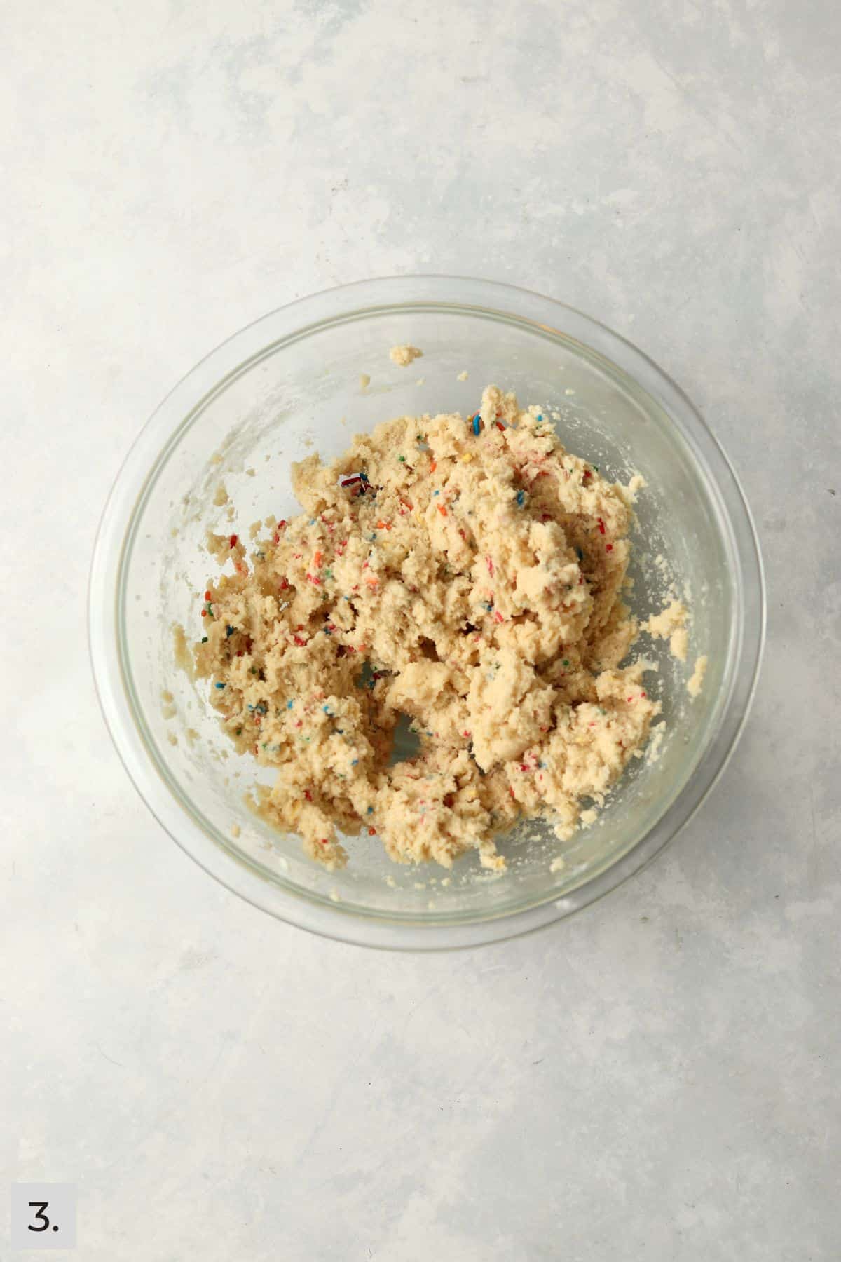 Sprinkle sugar cookie dough in a mixing bowl.