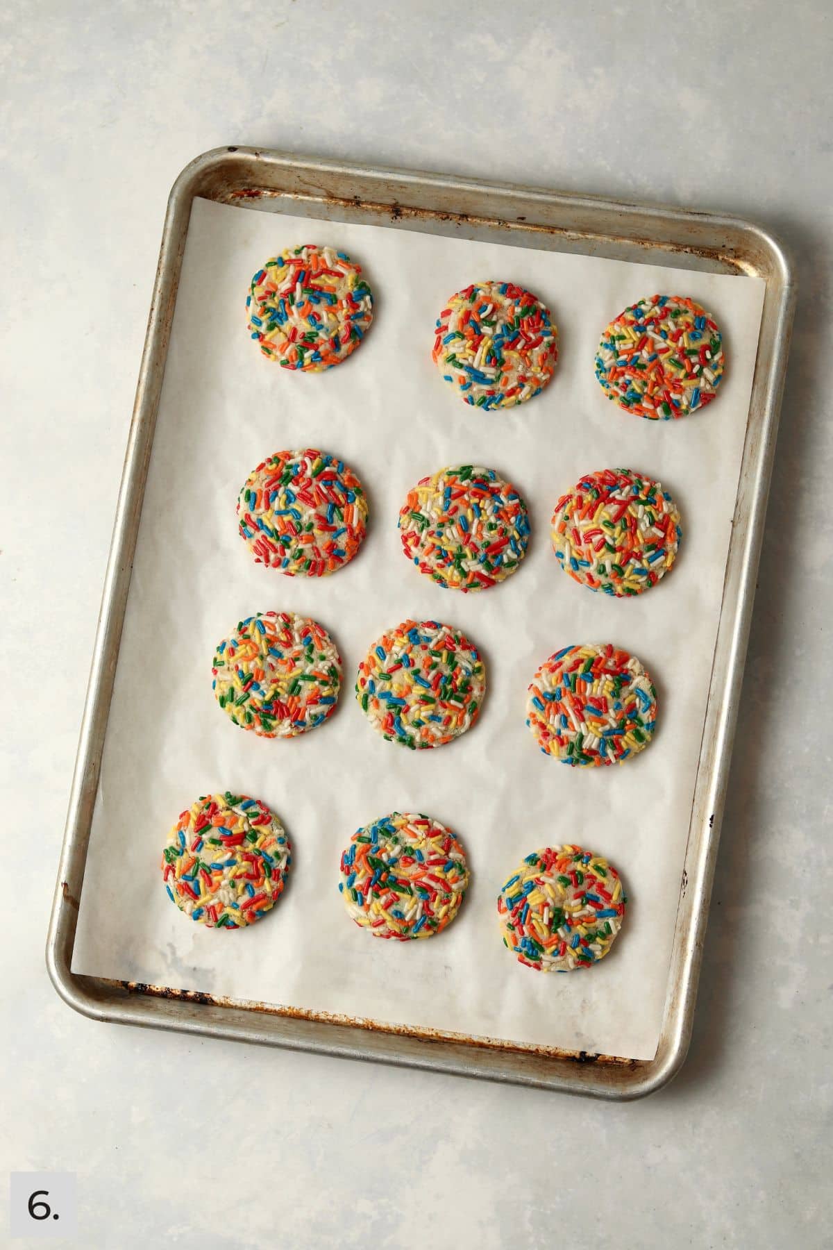 Baked sprinkle cookies on a baking sheet.