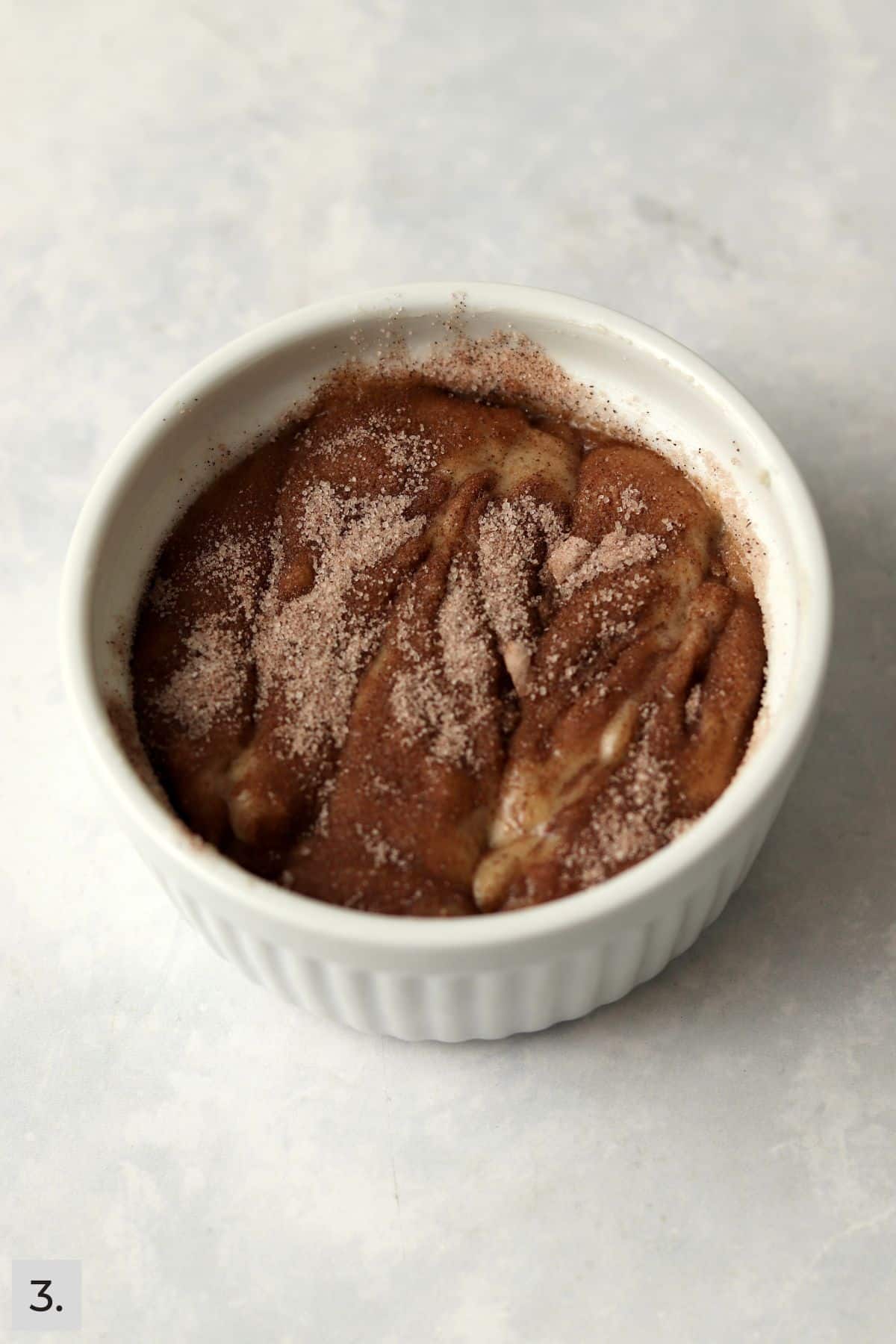Unbaked single serve cinnamon swirl banana bread in a ramekin.