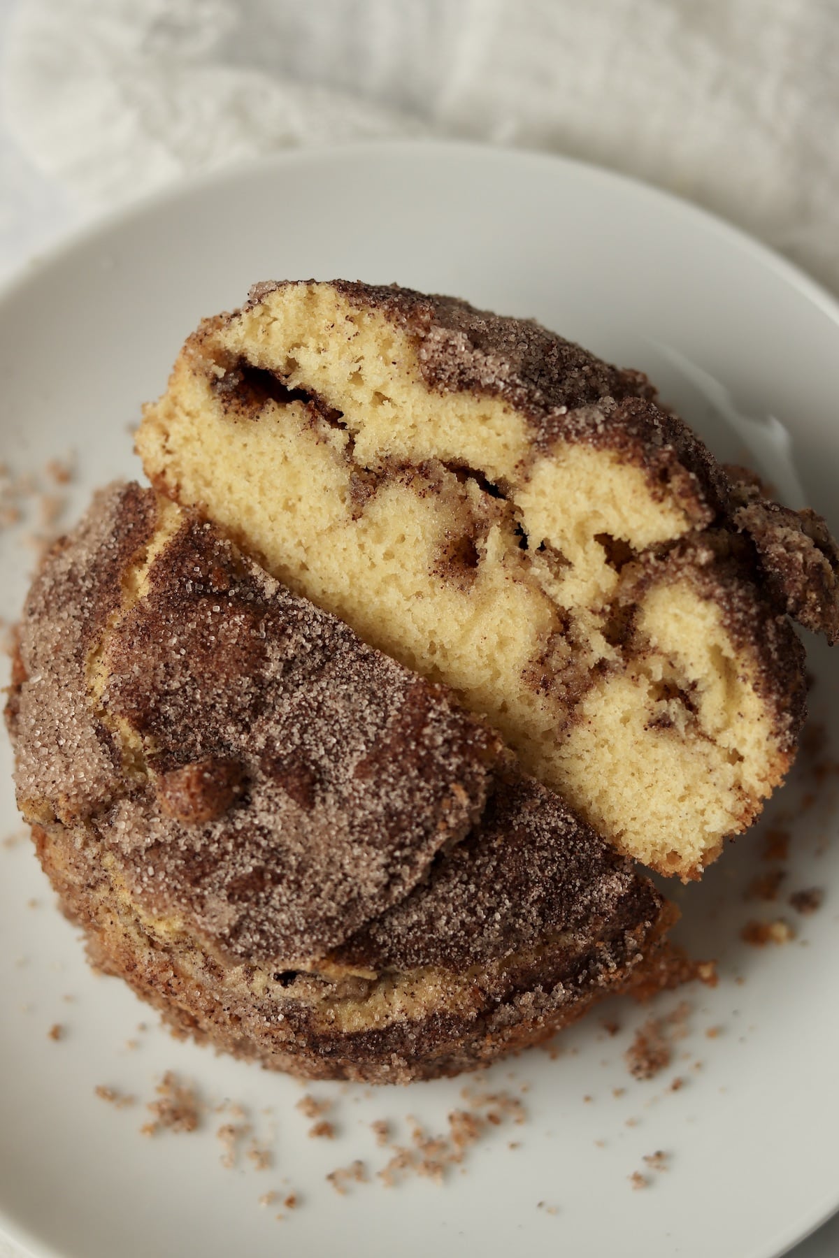 Single serve cinnamon swirl cake cut in half to show cinnamon sugar center.