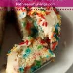 Fork taking a bite of a single serve funfetti cake with frosting.
