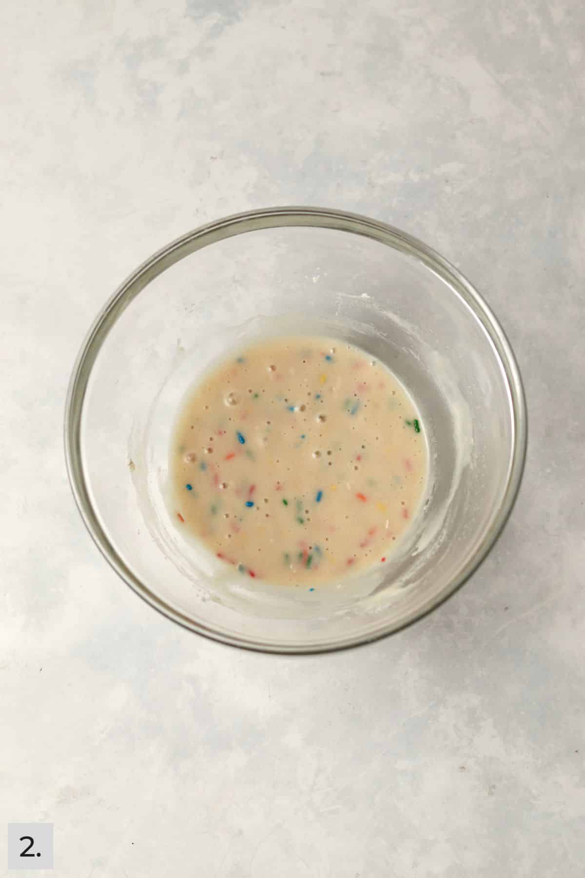 Confetti cake batter with sprinkles in a small mixing bowl.