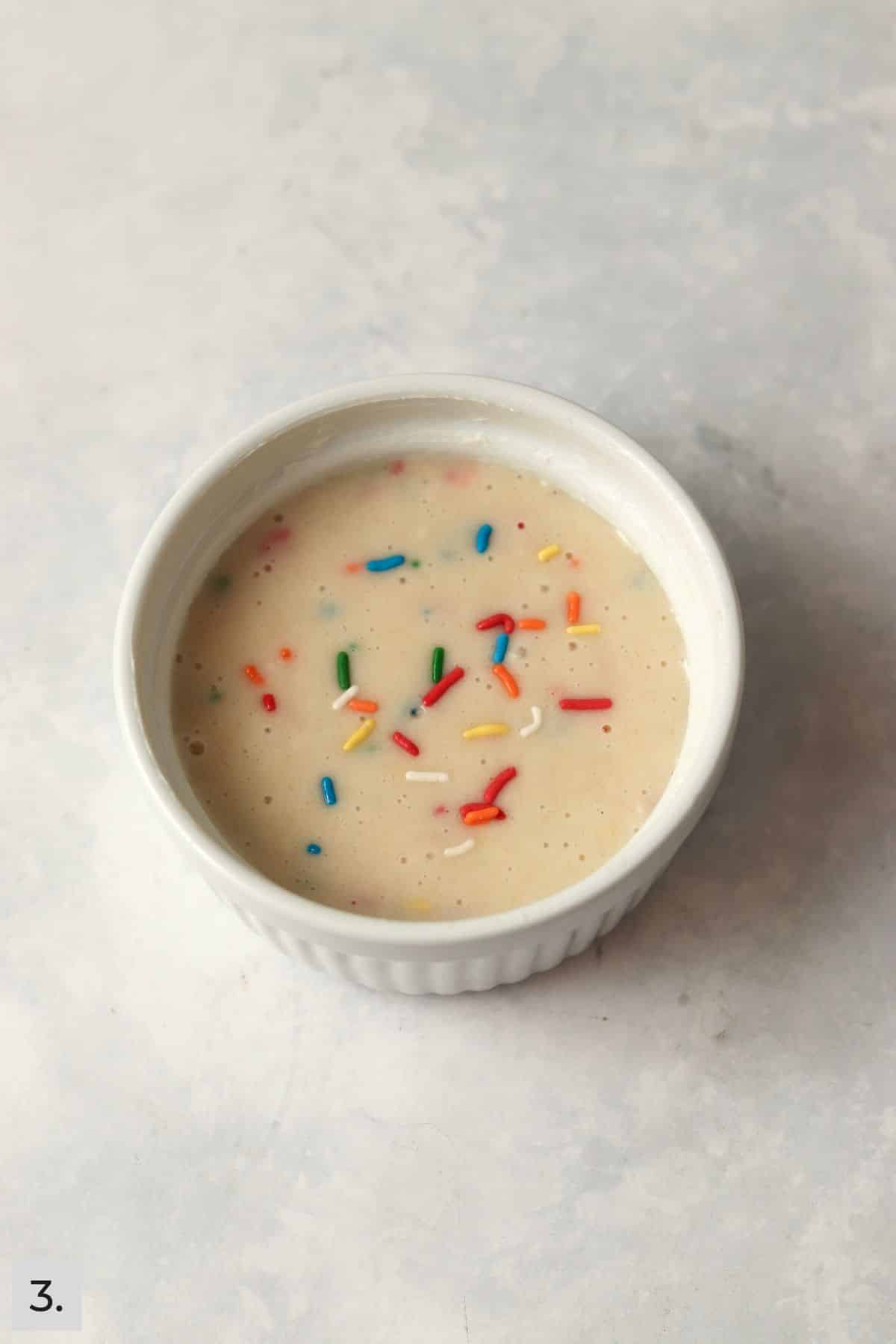 Greased ramekin with confetti cake batter.