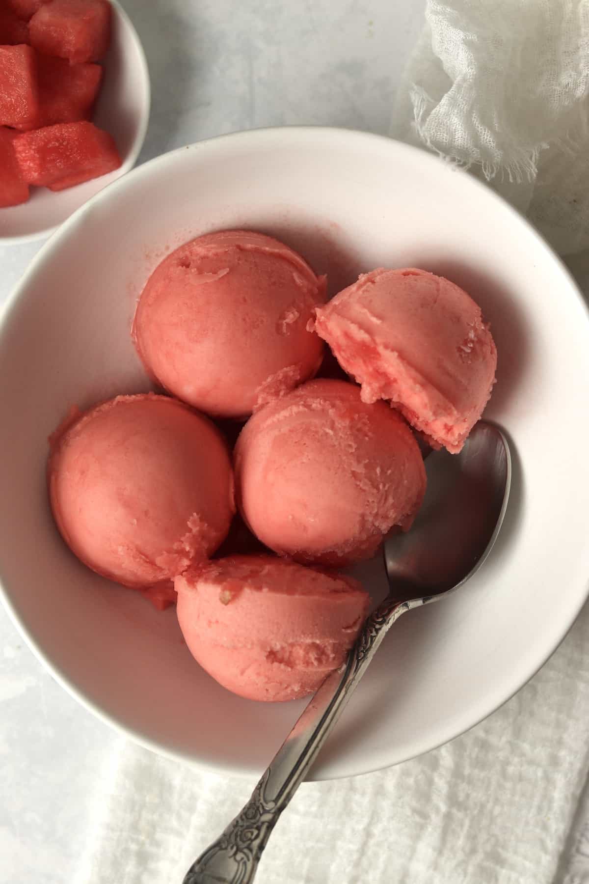 Scoops of watermelon sorbet in a bowl.