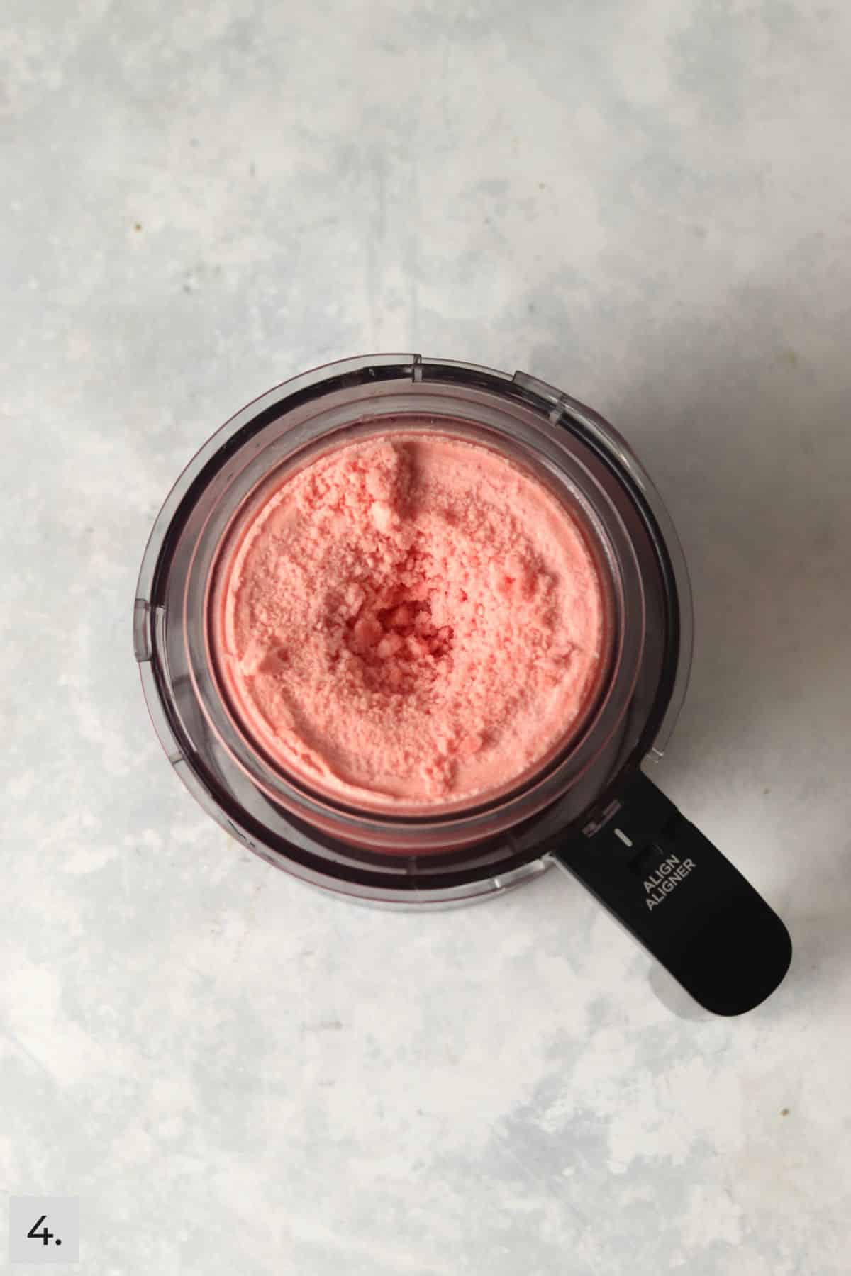 Crumbly watermelon sorbet base in Ninja Creami pint container.