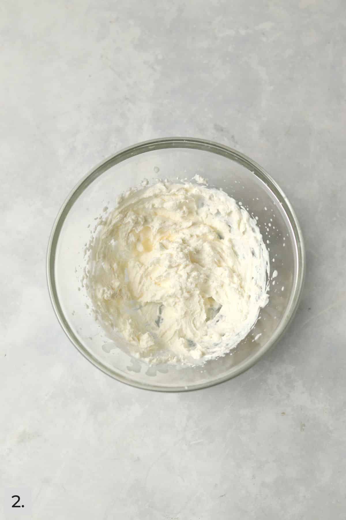 Cream whipped in a glass bowl.