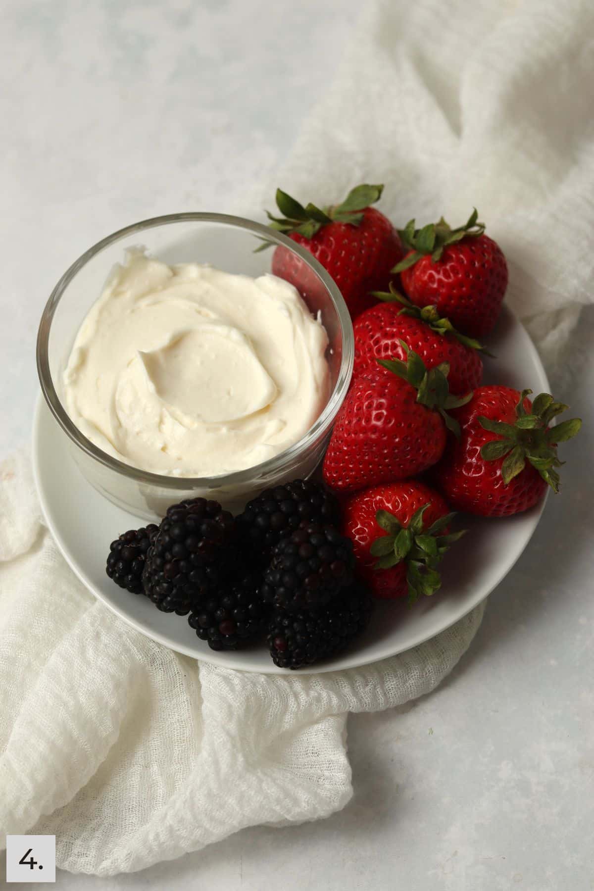 Single serve fruit dip on a plate with berries.