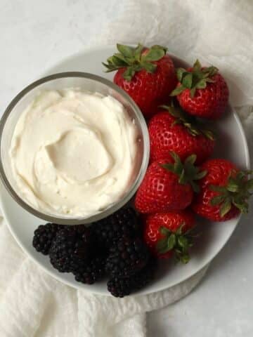 Single serve fruit dip on a plate with berries.
