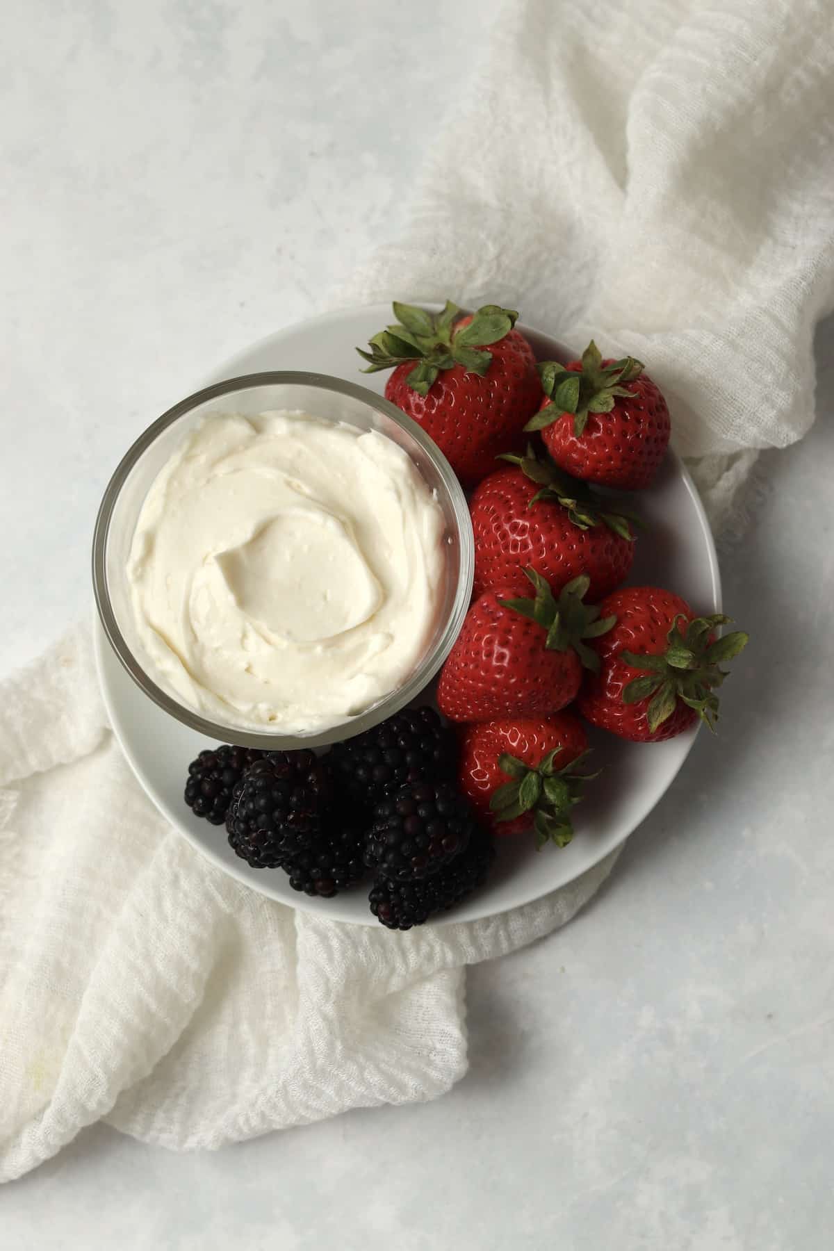 Single serve fruit dip on a plate with berries.