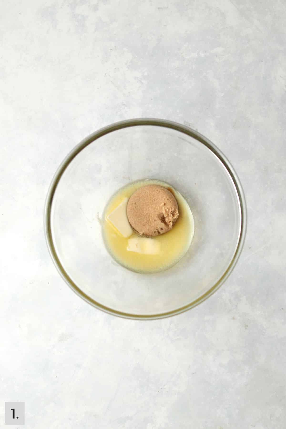 Butter and brown sugar warmed in a glass bowl.