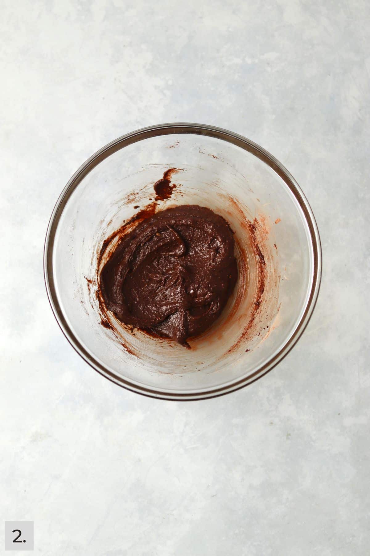 Small batch of brownie batter in a glass bowl.