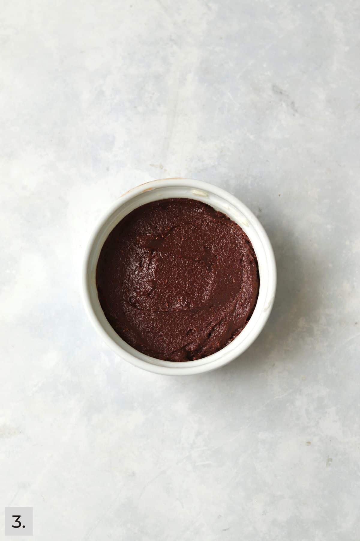 Unbaked single serve brownie in a ramekin.