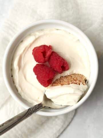 Single serve no bake cheesecake in a ramekin topped with berries.