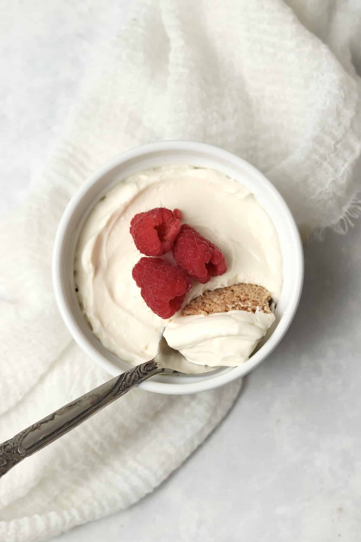 Single serve no bake cheesecake in a ramekin topped with berries.