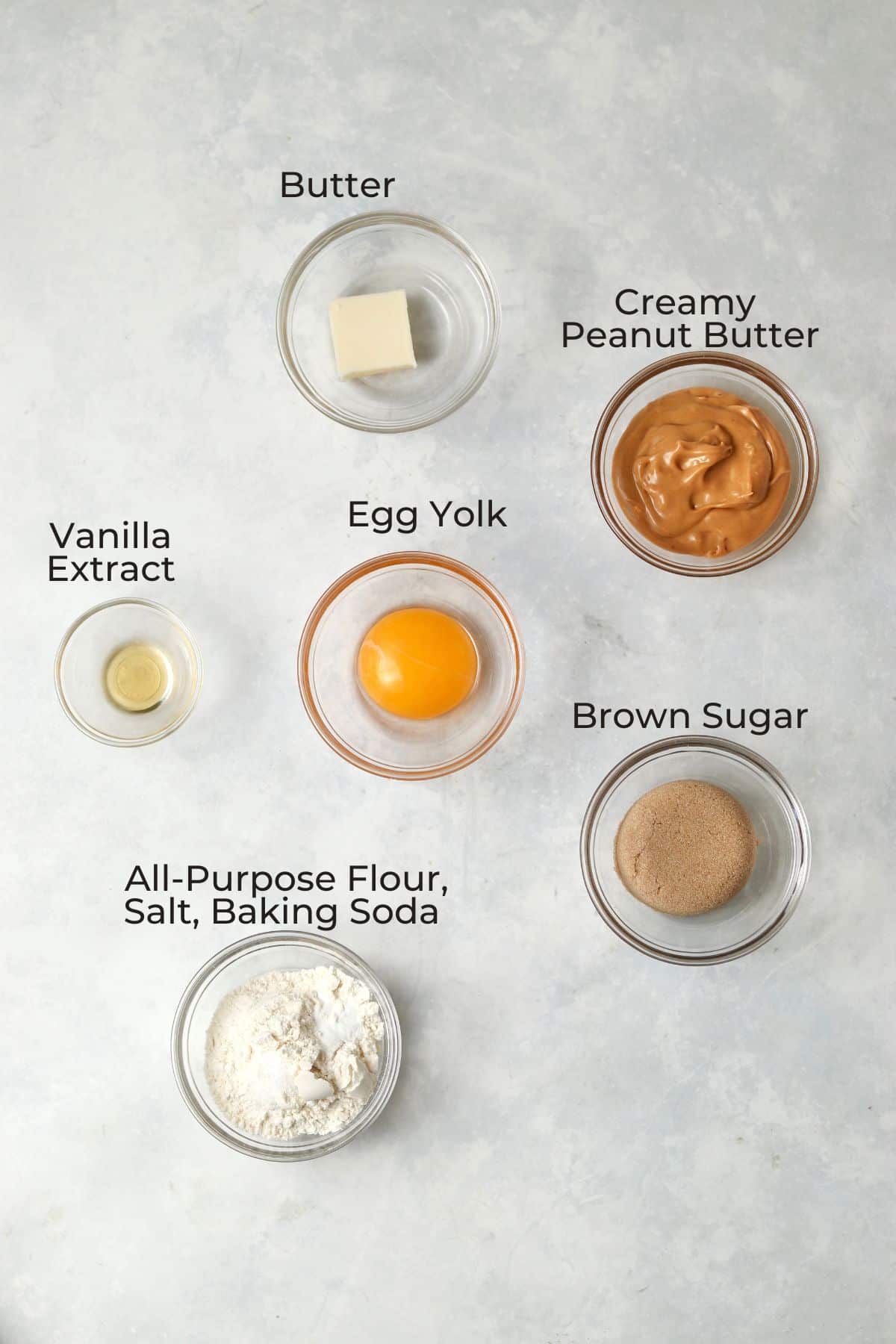 Peanut butter cookie ingredients in small glass prep bowls.