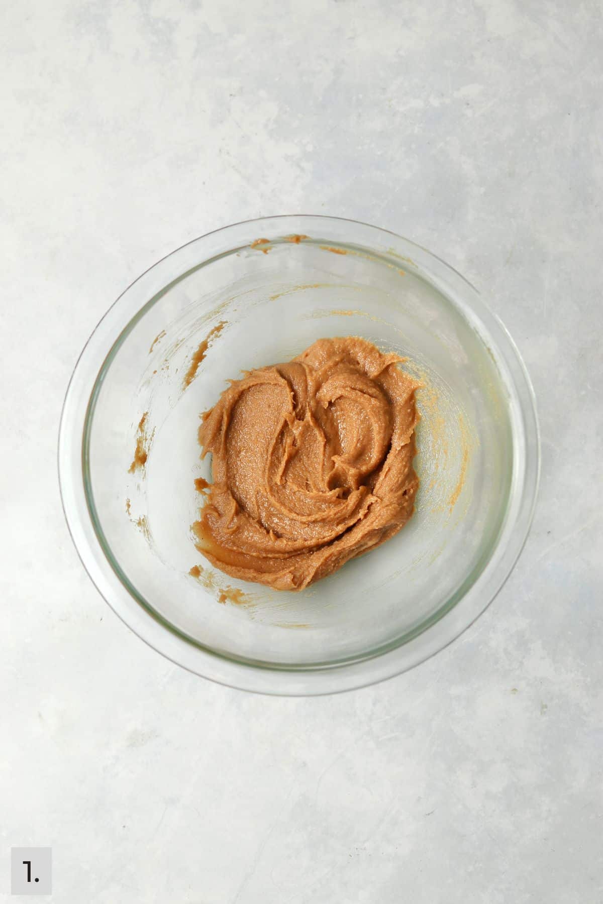 Peanut butter mixed with butter and sugar in a glass bowl.