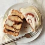 Single serve cinnamon roll with icing on a plate.