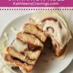 Single cinnamon roll cut in half on a plate.
