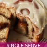 Iced single serve cinnamon roll on a plate.