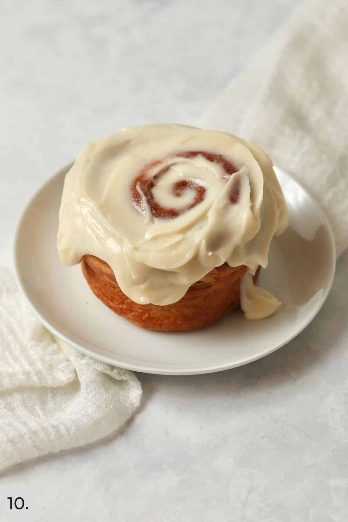 Single serve cinnamon roll with icing on a plate.