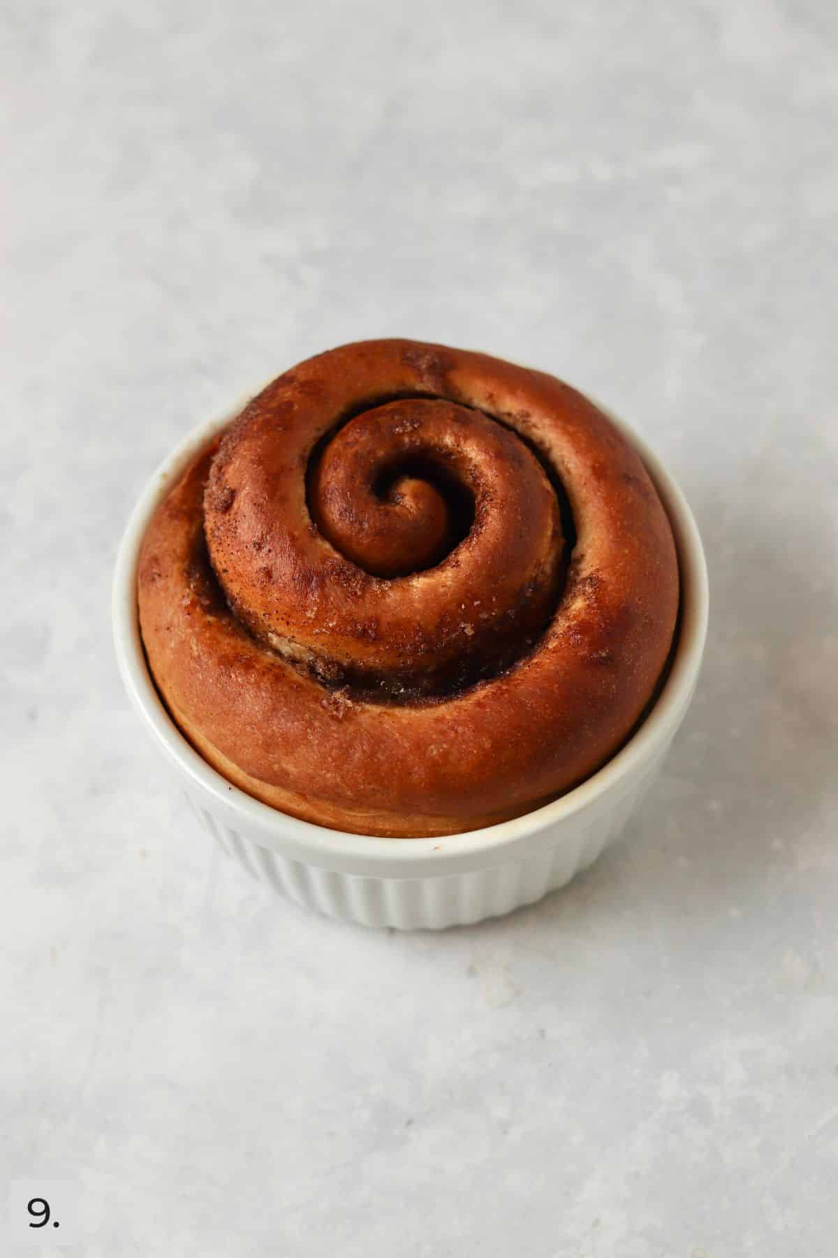 Single cinnamon roll in a ramekin after baking.