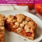 Single serve peach crumb bar cut in half on a plate.