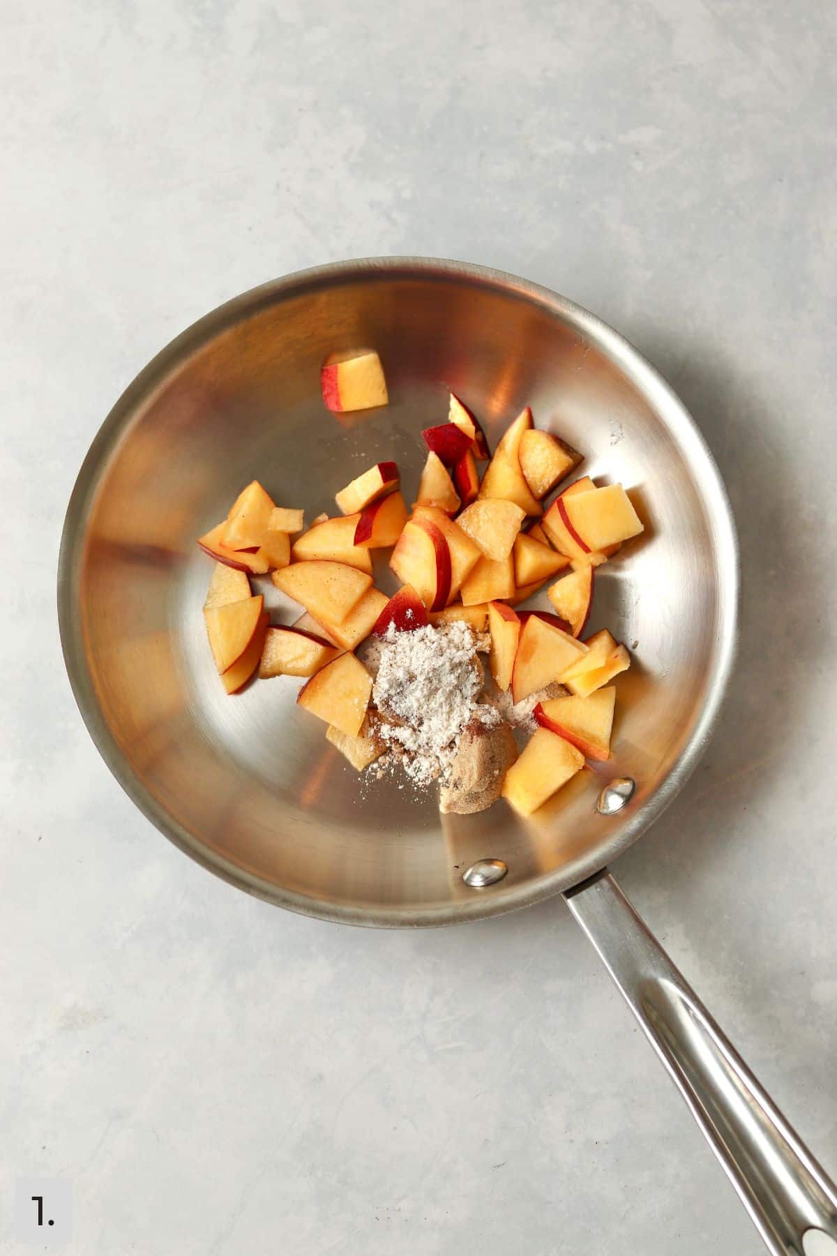 Fresh peaches, flour, brown sugar, and cinnamon in a small skillet.