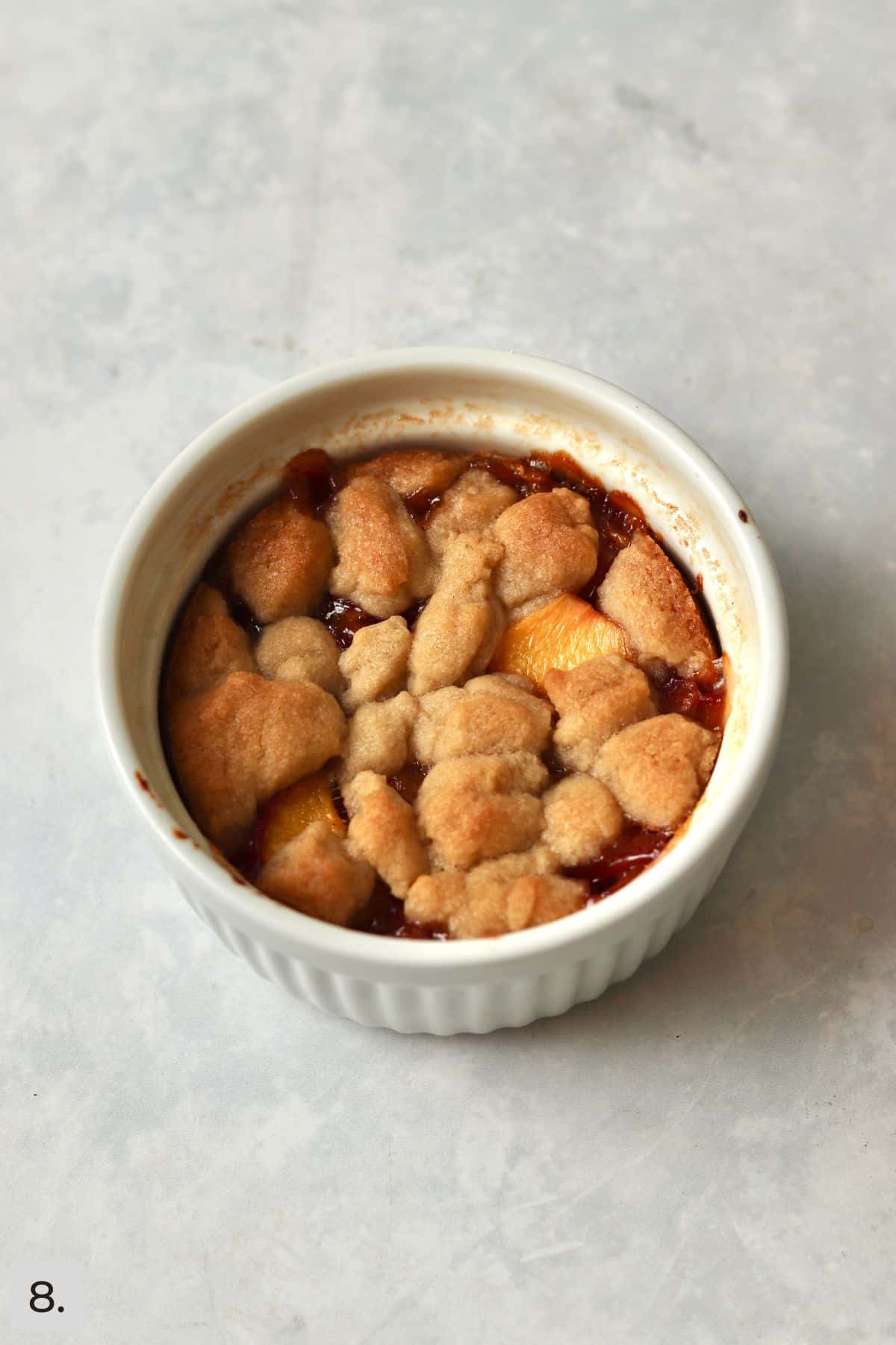 Single serve peach crumb bar baked in a ramekin.