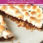 An individual layered s'mores bar with a graham cracker crust and marshmallows.