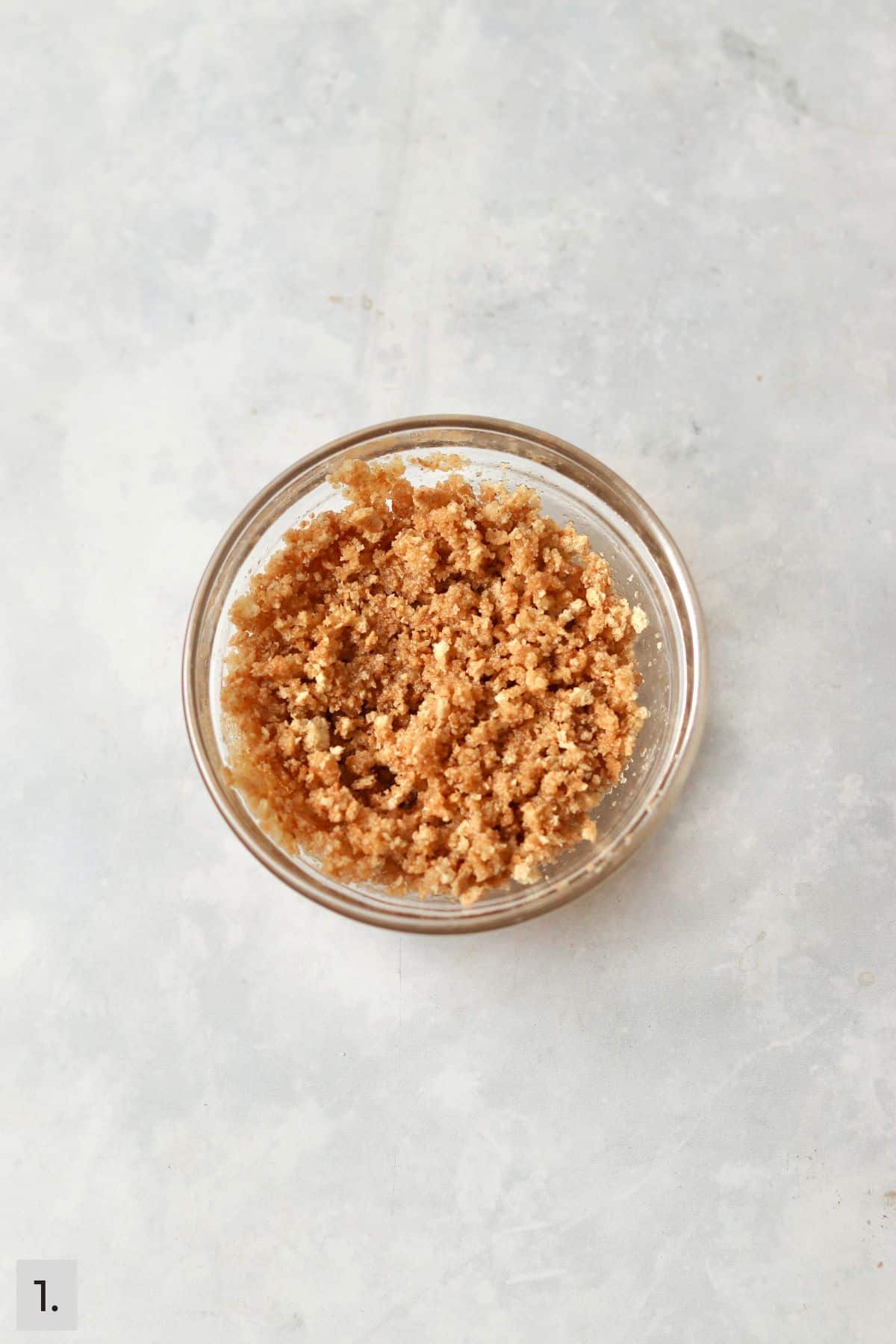Graham cracker crust mixture in small bowl.