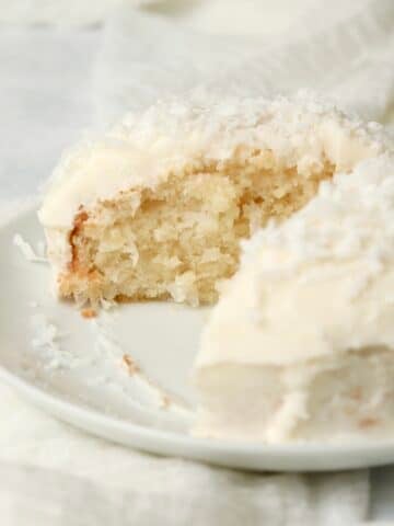 Single serve coconut cake with coconut frosting on a plate.