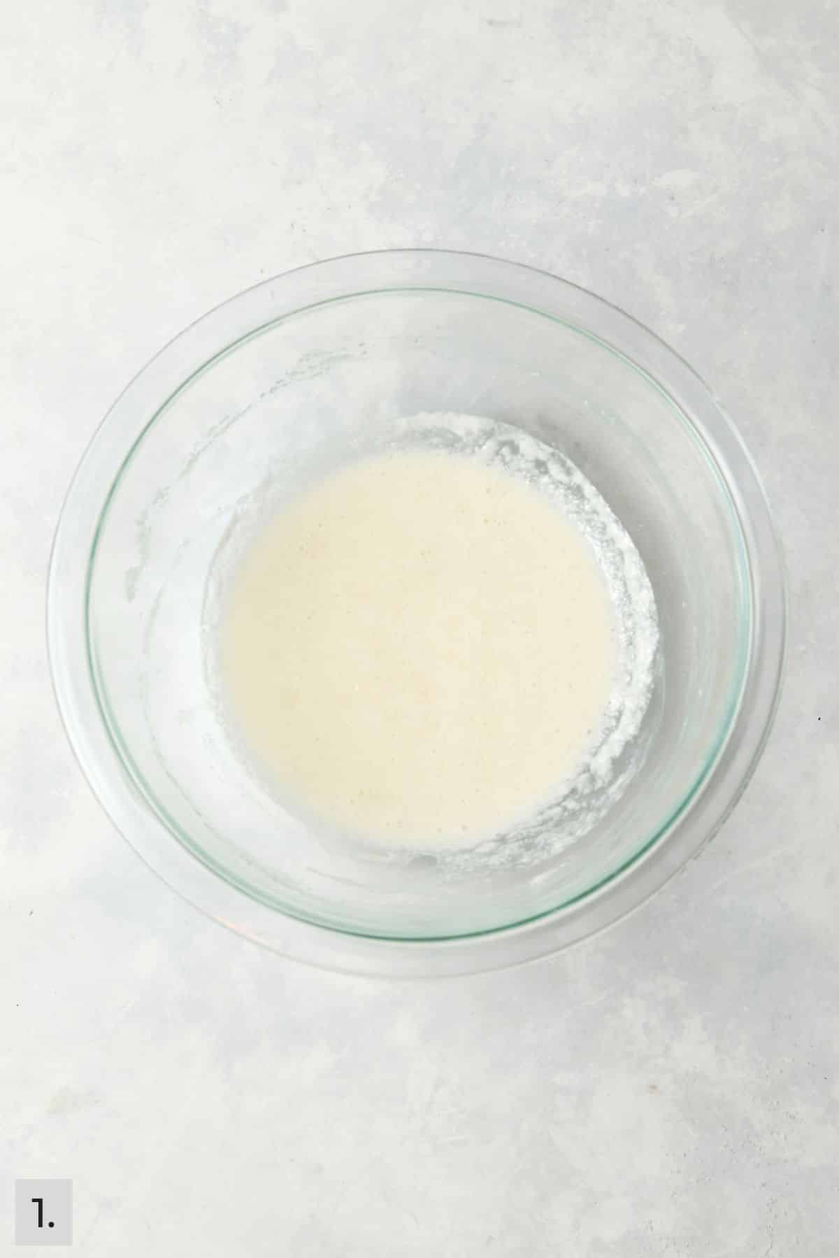 Wet ingredients for coconut cake batter in a mixing bowl.