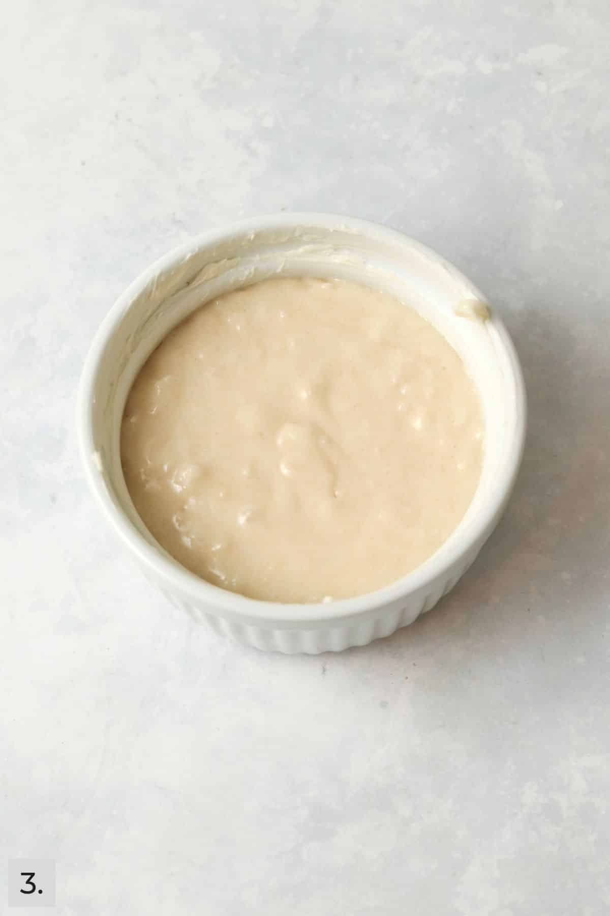 Unbaked single serve coconut cake in a ramekin.