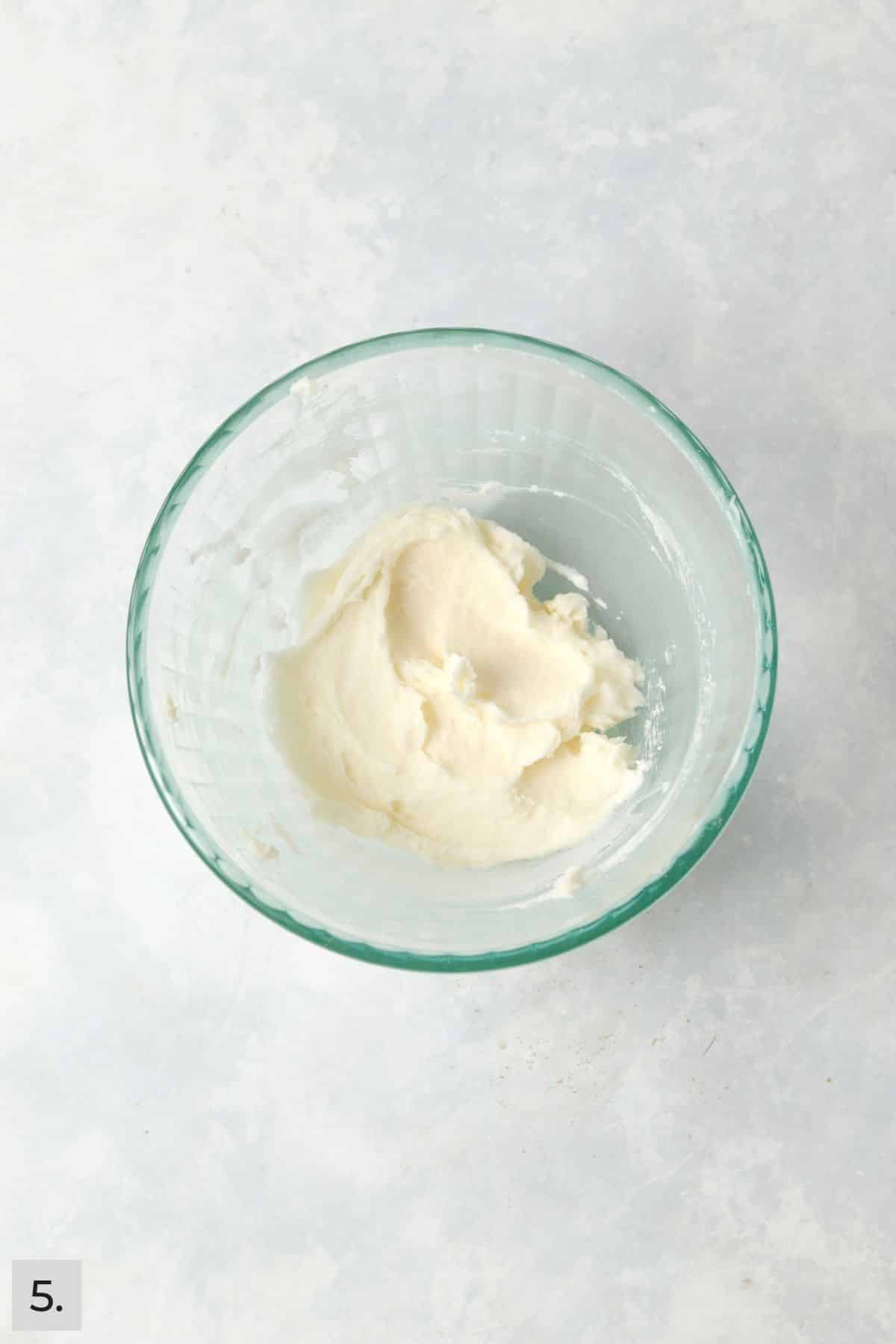 Small batch of coconut frosting in a mixing bowl.